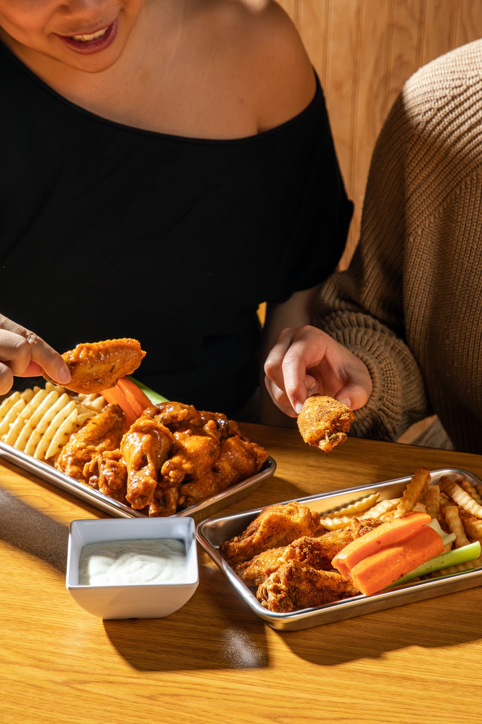 A guest eating wings at a table in Wing It, Jacksonville